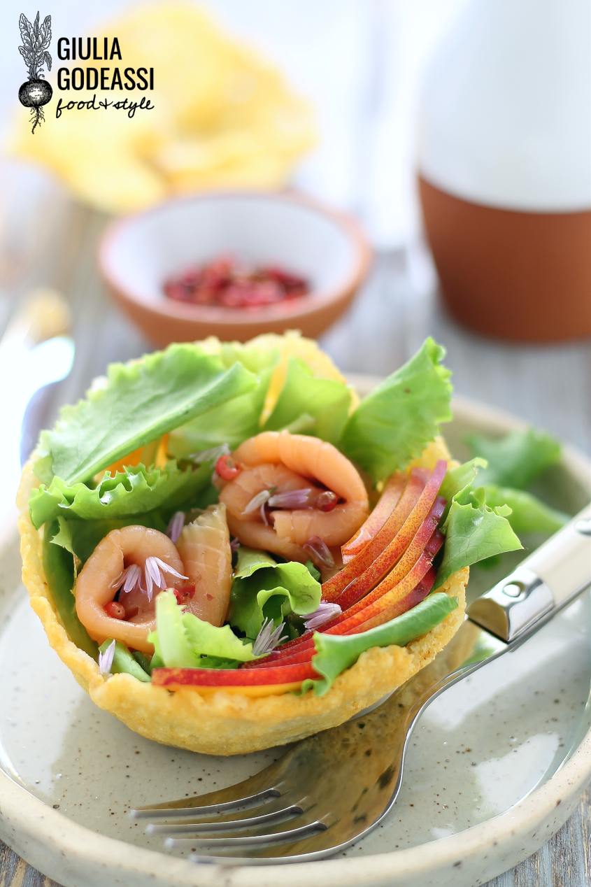 insalatina di pesche e trota  in un cestino di frico